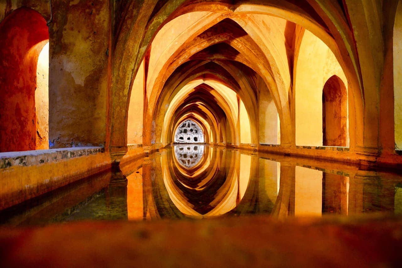 Vaulted stone arches reflected in still water